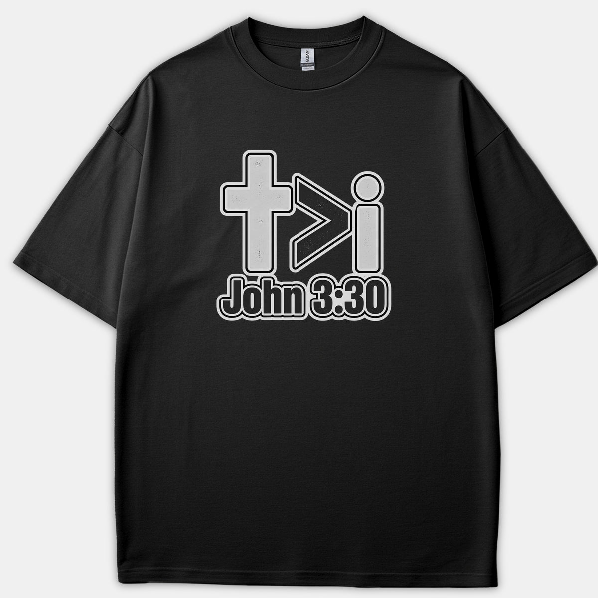 A black graphic T-shirt featuring a Christian design with a cross, a greater-than symbol, the letter i, and the Bible verse reference John 3:30 printed below.