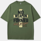 An olive green Christian t-shirt featuring a cross graphic with mountain peaks and distressed typography reading No Weapon Formed Shall Prosper Isaiah 54:17.