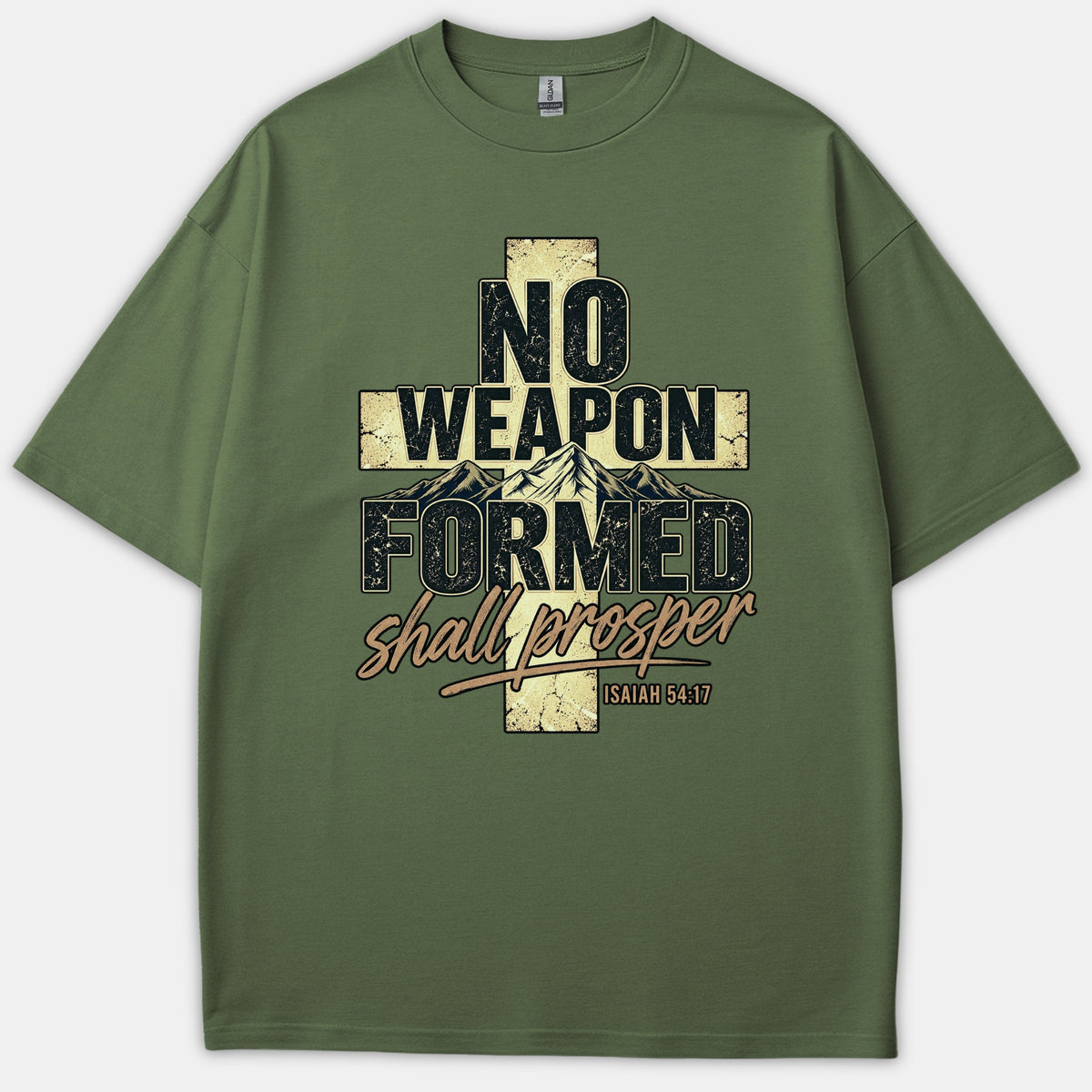 An olive green Christian t-shirt featuring a cross graphic with mountain peaks and distressed typography reading No Weapon Formed Shall Prosper Isaiah 54:17.