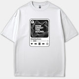 A white Christian t-shirt featuring a music player graphic design with a cross icon, soundwaves, and the lyrics How Sweet The Sound and Amazing Grace.
