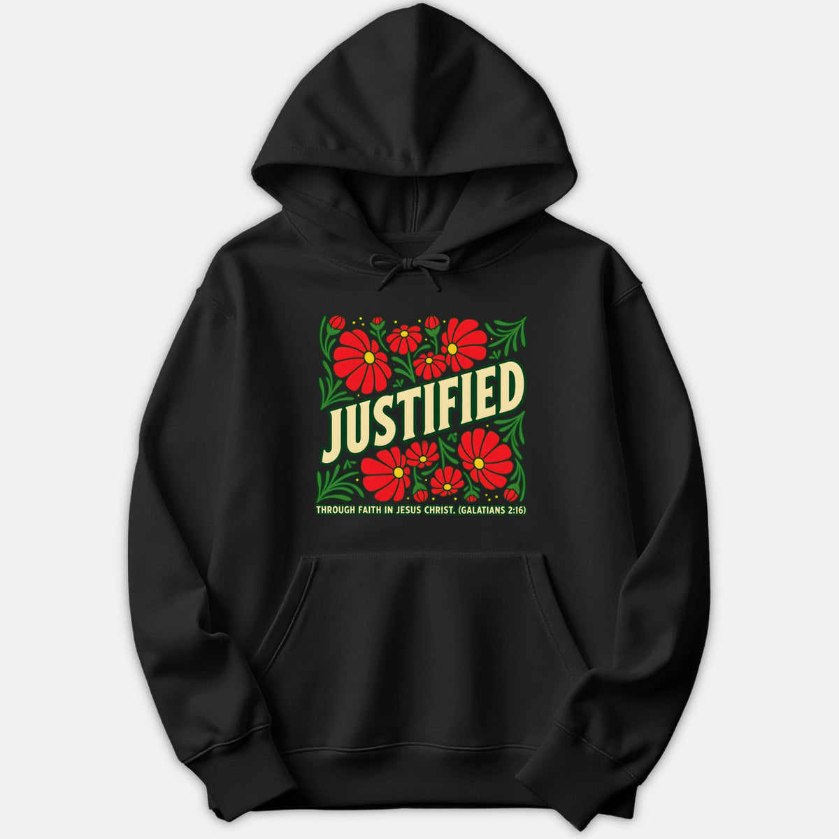 A black hoodie featuring a graphic design with red flowers, green foliage, and the text JUSTIFIED THROUGH FAITH IN JESUS CHRIST with scripture reference Galatians 2:16.