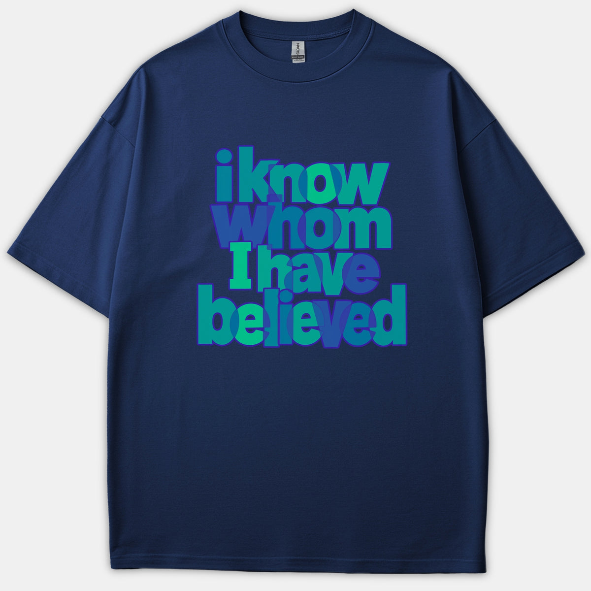A navy blue t-shirt featuring the Christian phrase 'i know whom I have believed' in layered blue and green typography across the front.