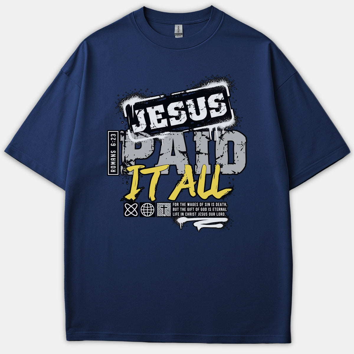 A navy blue Christian t-shirt featuring an urban graphic design with the words 'JESUS PAID IT ALL' and scripture reference Romans 6:23 styled in white, gray, and yellow fonts.
