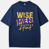 A navy blue t-shirt featuring a distressed graphic design that reads Wise Men Still Seek Him in bold yellow and purple typography.