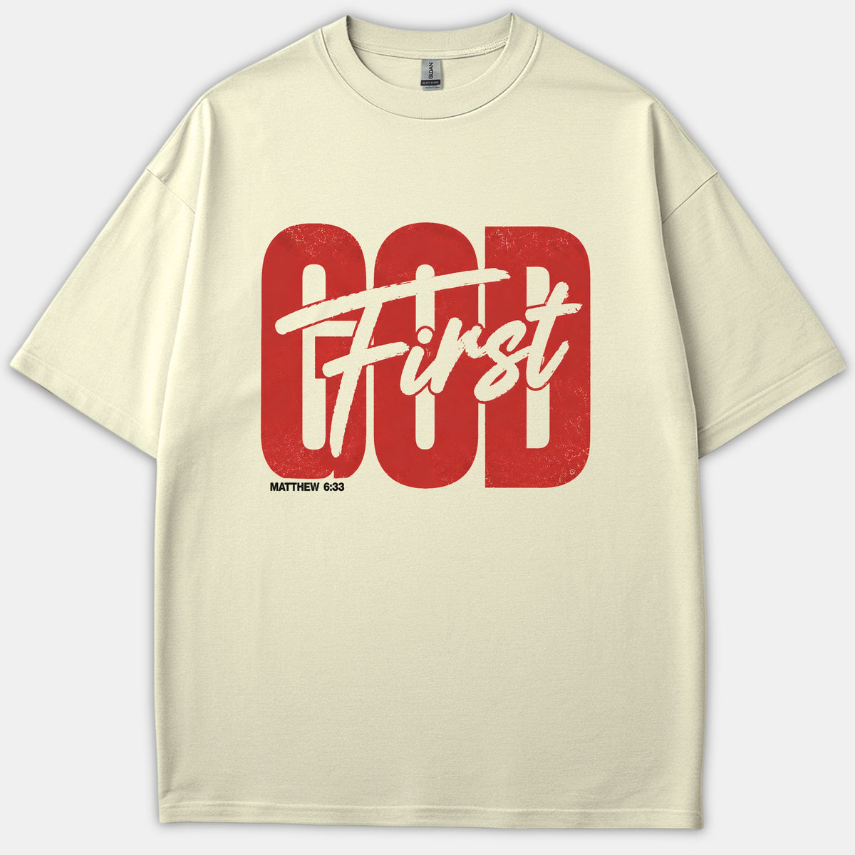 A beige Christian t-shirt featuring the phrase God First in bold red block font and off-white script, with the scripture reference Matthew 6:33 printed underneath.