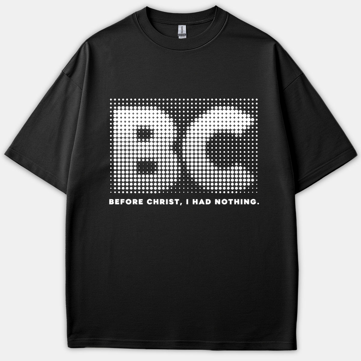 A black t-shirt featuring a white halftone dot graphic of the initials BC above the text BEFORE CHRIST, I HAD NOTHING.