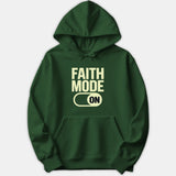 A dark green hoodie featuring the bold text FAITH MODE ON with an active toggle switch graphic printed across the front.