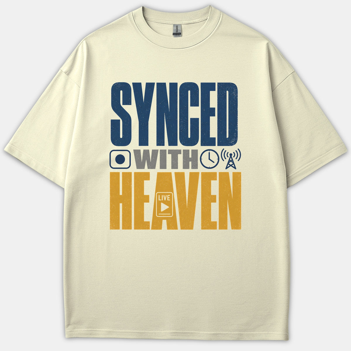 A beige Christian t-shirt featuring bold typography that reads 'SYNCED WITH HEAVEN' alongside media-themed icons in navy blue, gray, and gold.