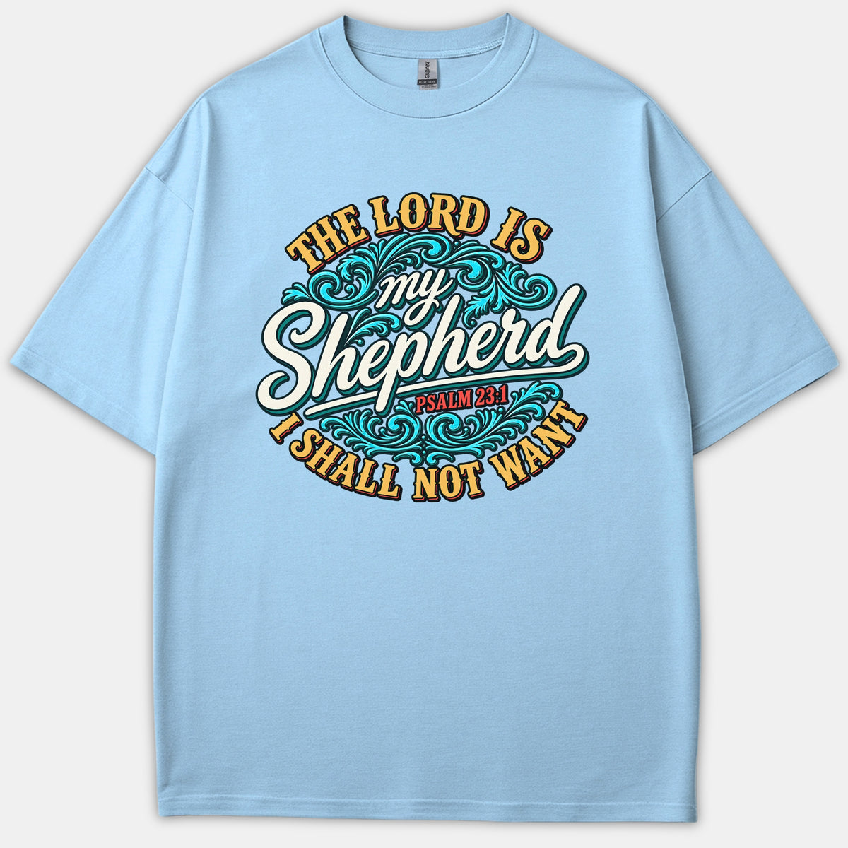 A light blue Christian t-shirt featuring ornate typography and cyan decorative scrollwork reading 'The Lord is my Shepherd, Psalm 23:1, I Shall Not Want'.