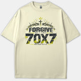A beige T-shirt featuring a Christian graphic design that reads 'FORGIVE NOT 7 TIMES 70X7' with a cross, crown of thorns, and the scripture reference Matthew 18:21-22.