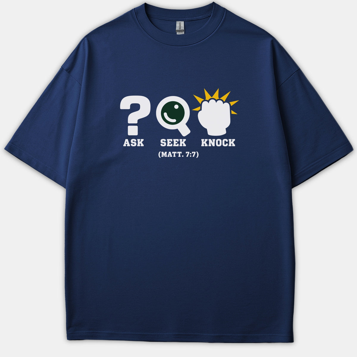 A navy blue Christian t-shirt featuring graphic symbols for Ask, Seek, and Knock along with the Bible verse reference Matthew 7:7 in bold white typography.