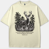 A beige T-shirt featuring a detailed black line illustration of a deer in a forest with the Bible verse Psalm 42:1 printed underneath.