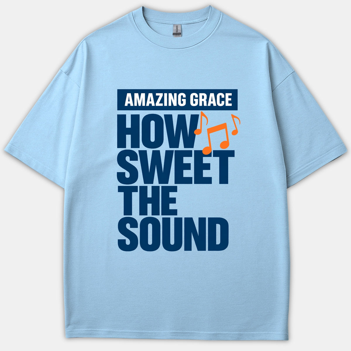 A light blue Christian T-shirt displaying the bold phrase Amazing Grace How Sweet The Sound in navy blue with vibrant orange musical notes.