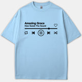 A light blue Christian t-shirt featuring a black music player interface graphic with the text Amazing Grace How Sweet The Sound.