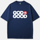 A navy blue t-shirt featuring the phrase GOD IS GOOD in bold white text with the word IS enclosed inside a red circle.