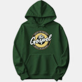 A dark green hoodie featuring a circular graphic print with 'Amplify the Good News' written around white script text reading 'the Gospel'.