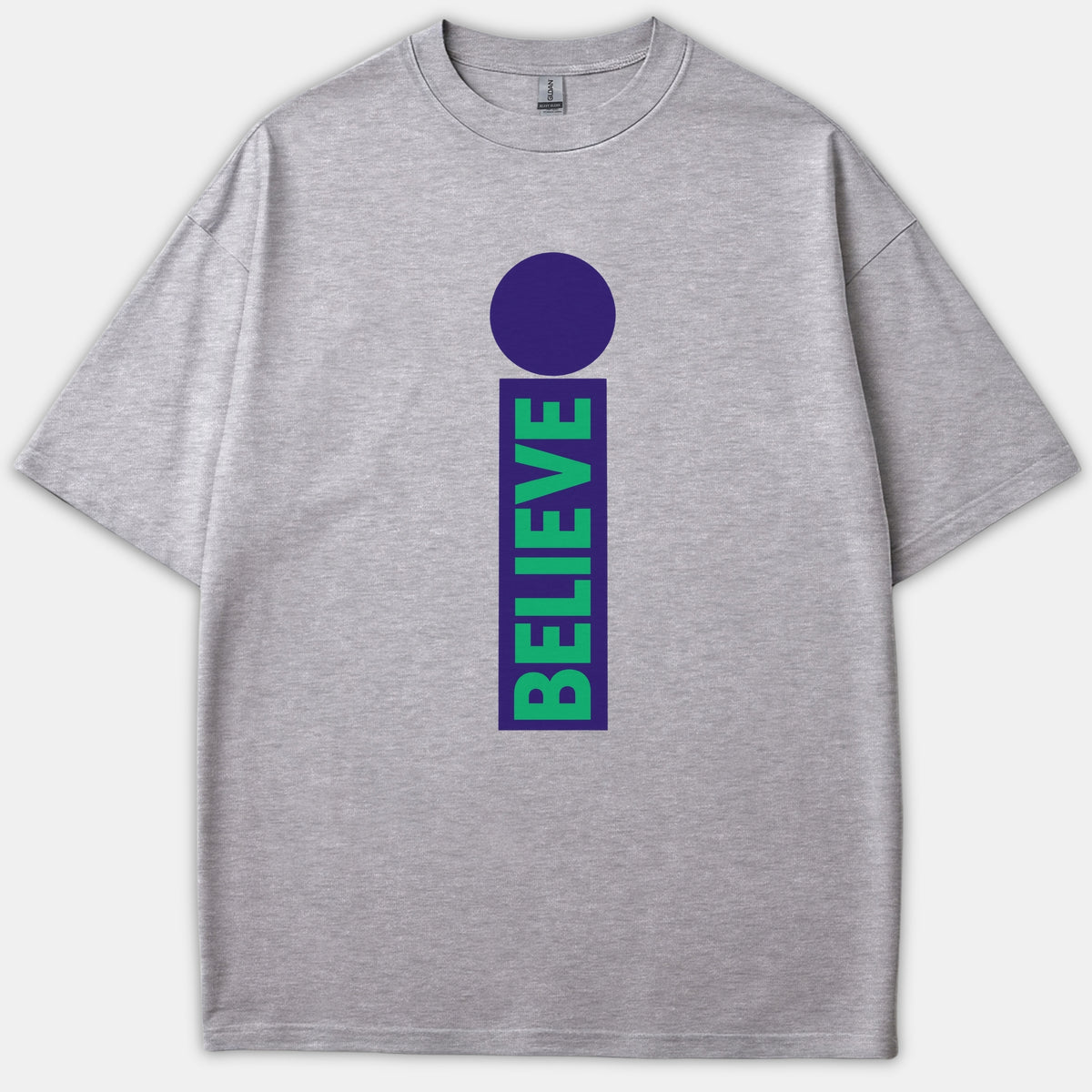 A heather gray t-shirt featuring a purple lowercase letter i graphic with the word BELIEVE written vertically in green inside the stem.