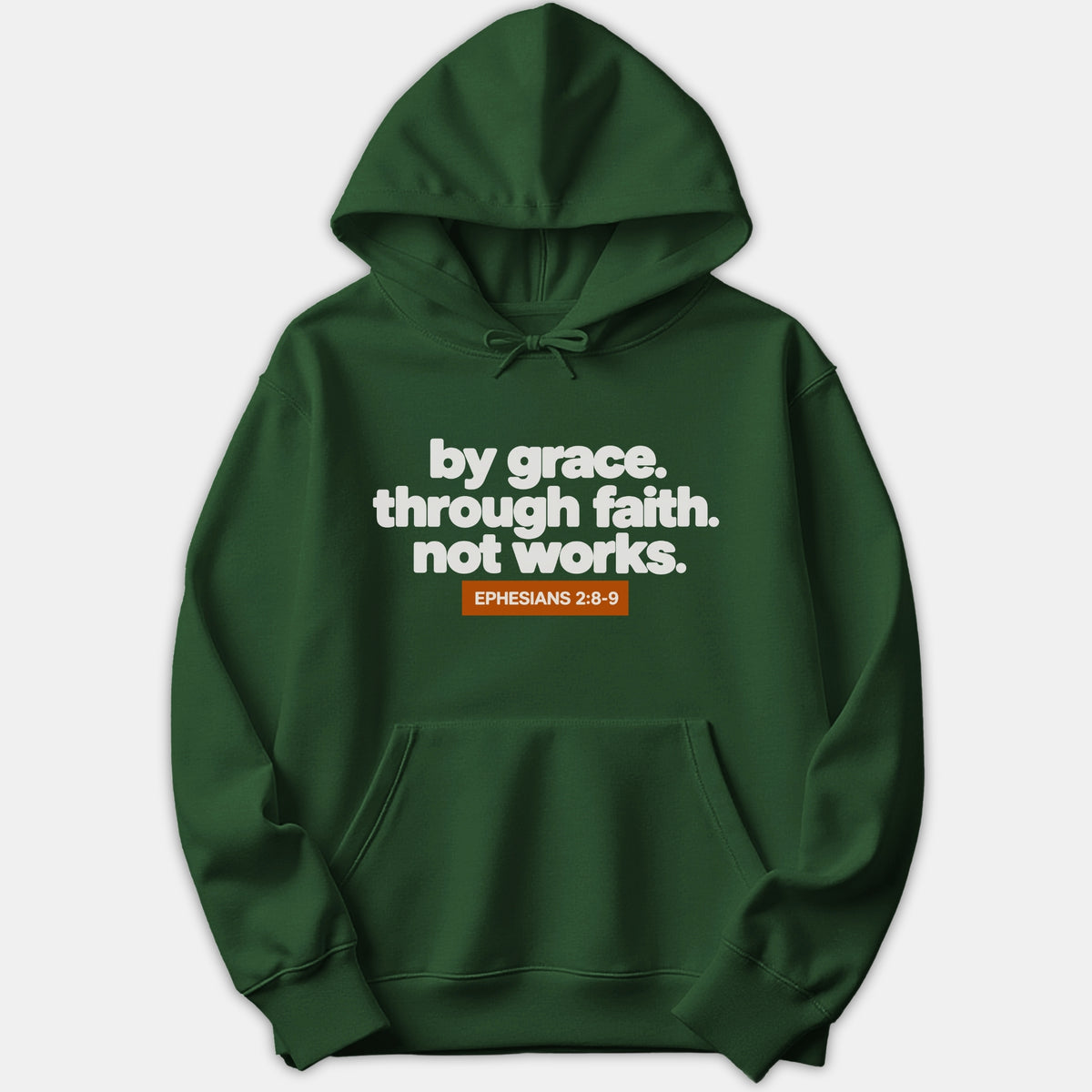 A dark green Christian hoodie featuring white text that reads 'by grace. through faith. not works.' above an orange box containing 'EPHESIANS 2:8-9'.