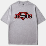 A gray Christian t-shirt featuring the name Jesus in bold red and black lettering, styled with a superhero Superman-inspired diamond emblem.