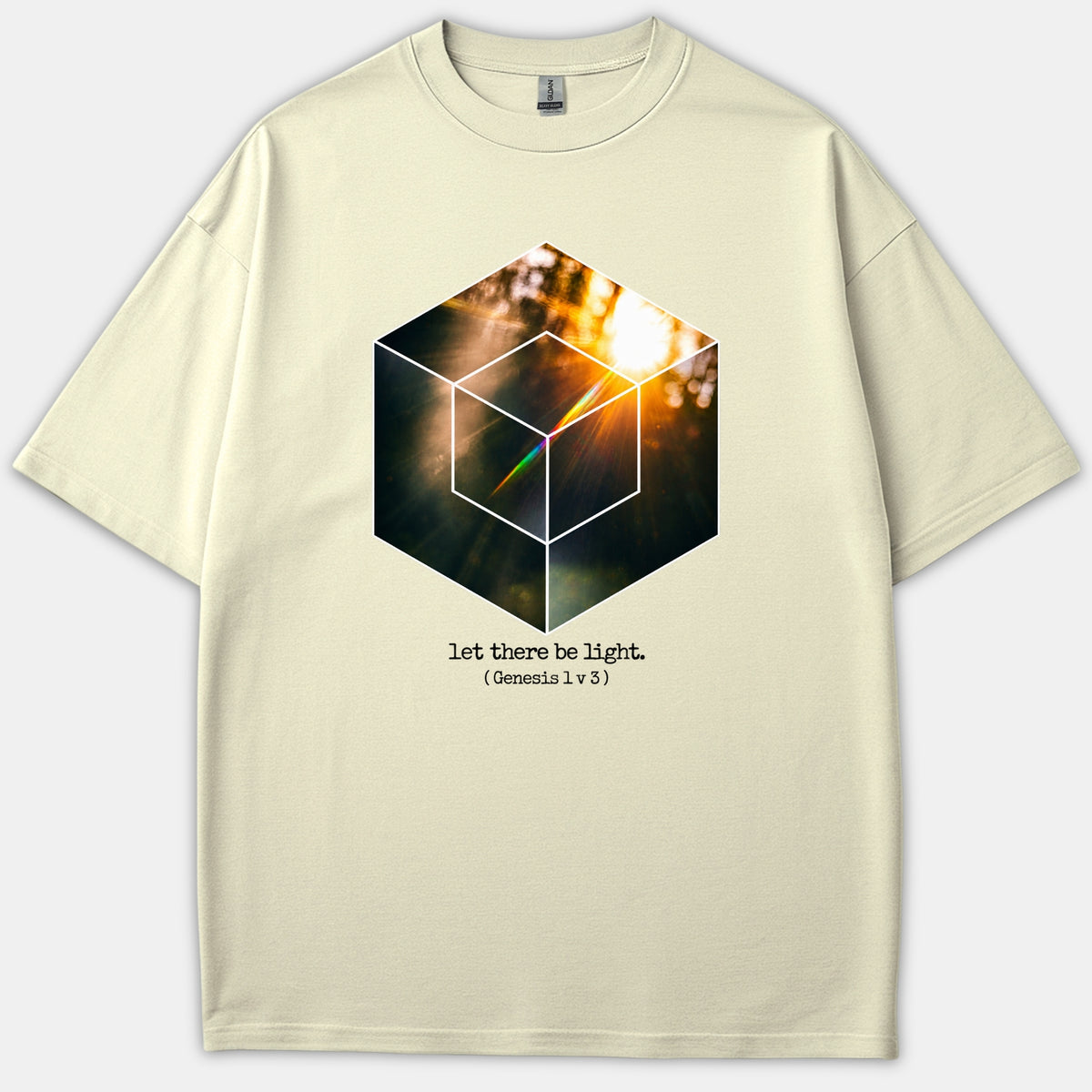 A beige graphic Christian t-shirt featuring a geometric cube filled with a glowing sunlight photo and the caption let there be light Genesis 1 v 3 printed below.