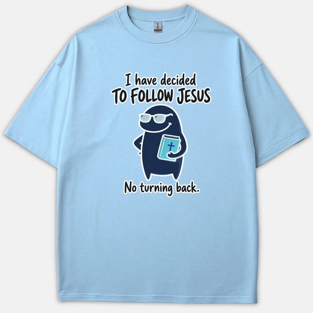 A light blue Christian T-shirt featuring a cute cartoon character wearing sunglasses and holding a Bible, flanked by the text, 'I have decided to follow Jesus, no turning back.'
