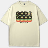 A beige Christian t-shirt featuring retro layered typography that reads 'GOD IS GOOD' with 'PSALM 34:8' printed below in black, green, orange, and yellow hues.