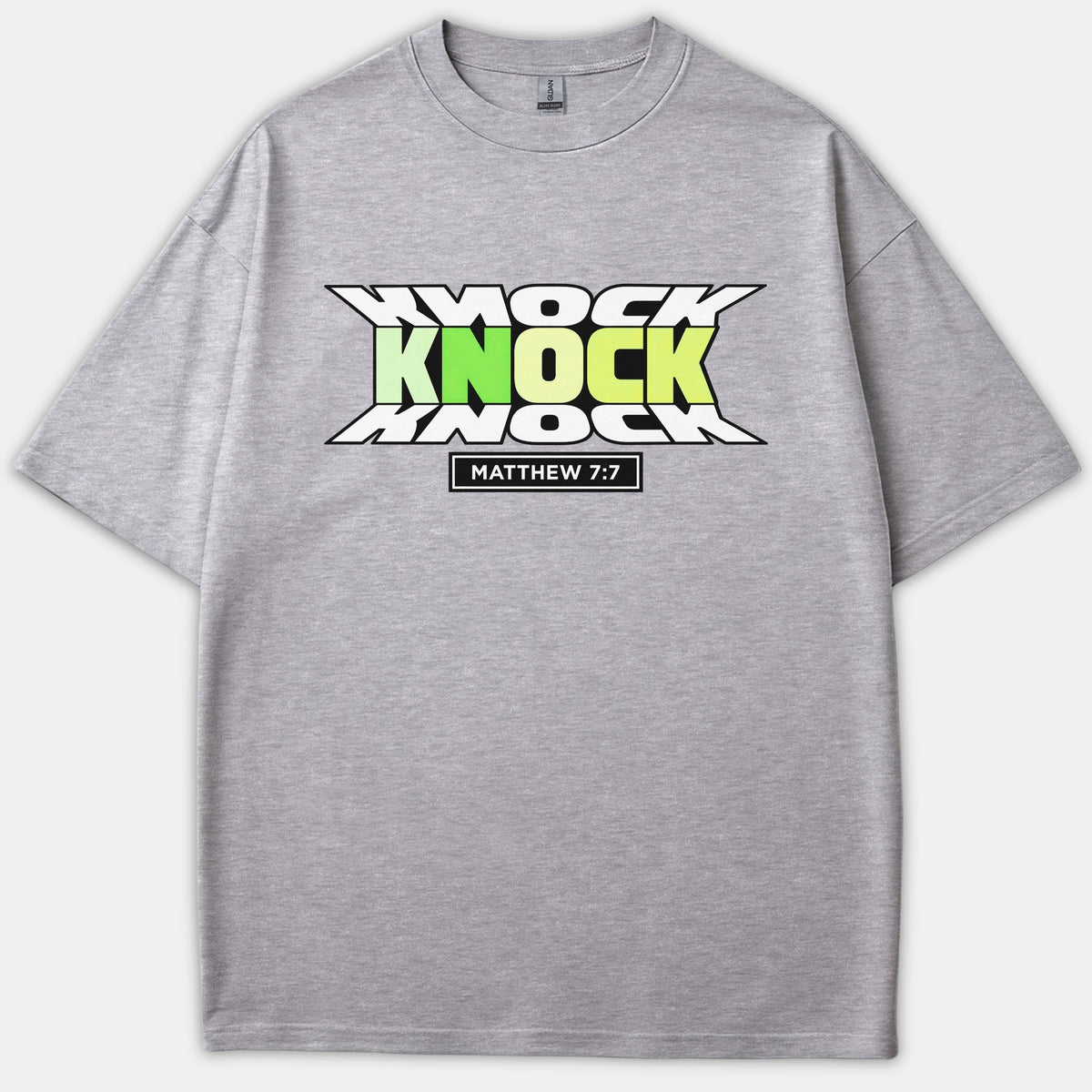A gray t-shirt featuring a bold graphic reading 'KNOCK KNOCK KNOCK' with a green-to-yellow gradient and 'MATTHEW 7:7' inside a black box underneath.