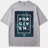 A gray Christian t-shirt featuring a mountain landscape under green northern lights with the word FORGIVEN inside a white box and Colossians 2:13 printed below.