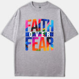 A gray t-shirt featuring a vibrant colorful brushstroke graphic that reads FAITH OVER FEAR printed across the front.