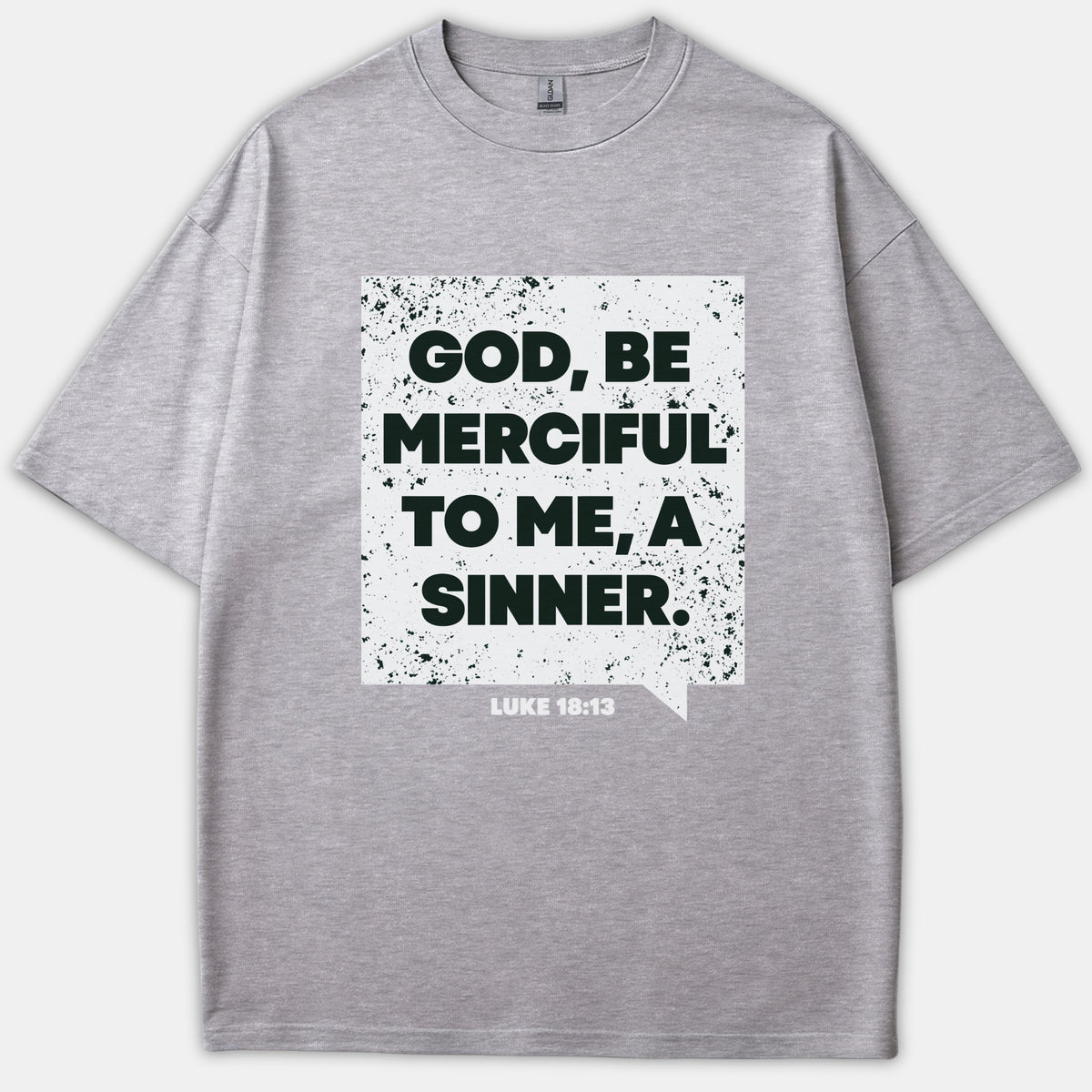 A gray t-shirt featuring a distressed white graphic that reads 'GOD, BE MERCIFUL TO ME, A SINNER' alongside the Scripture reference 'LUKE 18:13'.