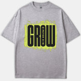 A gray t-shirt featuring a neon yellow distressed background graphic with the word GROW and scripture reference 2 Peter 3:18 printed in bold black.