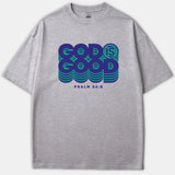 A gray Christian t-shirt featuring a retro graphic reading 'GOD IS GOOD' in bold blue and green layered text above 'PSALM 34:8'.