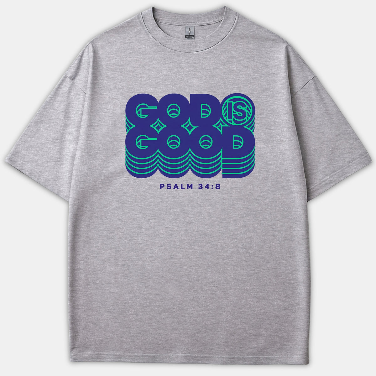 A gray Christian t-shirt featuring a retro graphic reading 'GOD IS GOOD' in bold blue and green layered text above 'PSALM 34:8'.