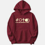 A red hoodie featuring Holy Week symbols including a palm branch, crown of thorns, cross, and empty tomb above the printed text A LOT CAN HAPPEN IN A WEEK.