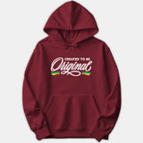 A maroon red hoodie featuring the graphic text CREATED TO BE Original in bold white lettering with green and yellow accents on the chest.