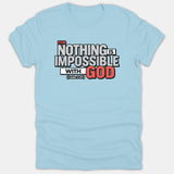 A light blue Christian t-shirt featuring the scripture quote 'FOR NOTHING IS IMPOSSIBLE WITH GOD' from Luke 1:37 in bold white, red, and black typography.
