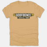 A beige Christian t-shirt featuring a graphic banner that reads Godfidence I Can Do All Things in bold white lettering framed by black and gold accents.