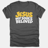 A dark gray t-shirt featuring the phrase 'JESUS MY SOUL'S BELOVED' printed on the front in bold yellow and white lettering.
