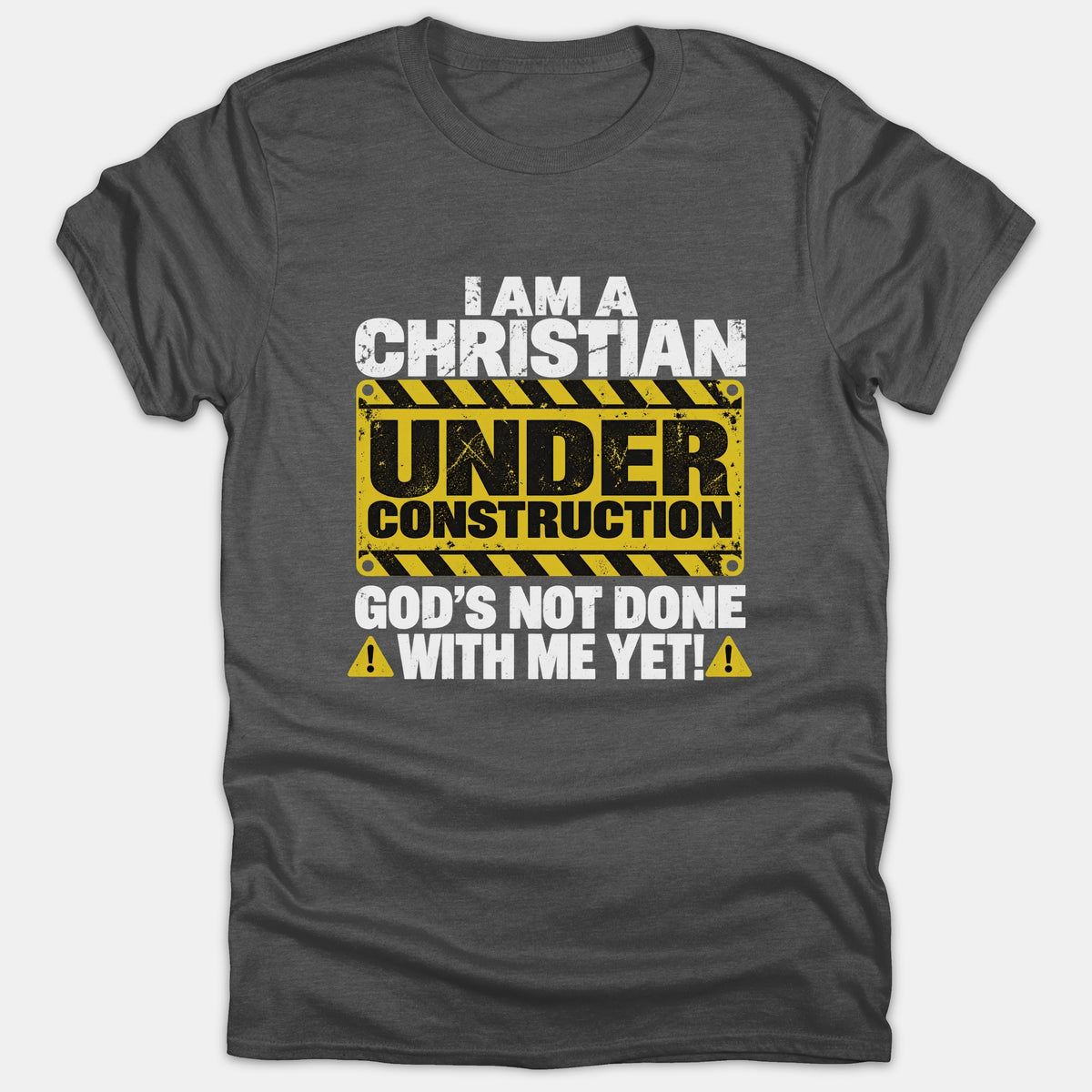 A dark gray t-shirt featuring a construction sign graphic with the text I Am A Christian Under Construction God's Not Done With Me Yet.
