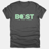 A dark gray Christian T-shirt featuring mint green text that reads BOAST IN THE LORD with an empty tomb graphic integrated into the lettering.