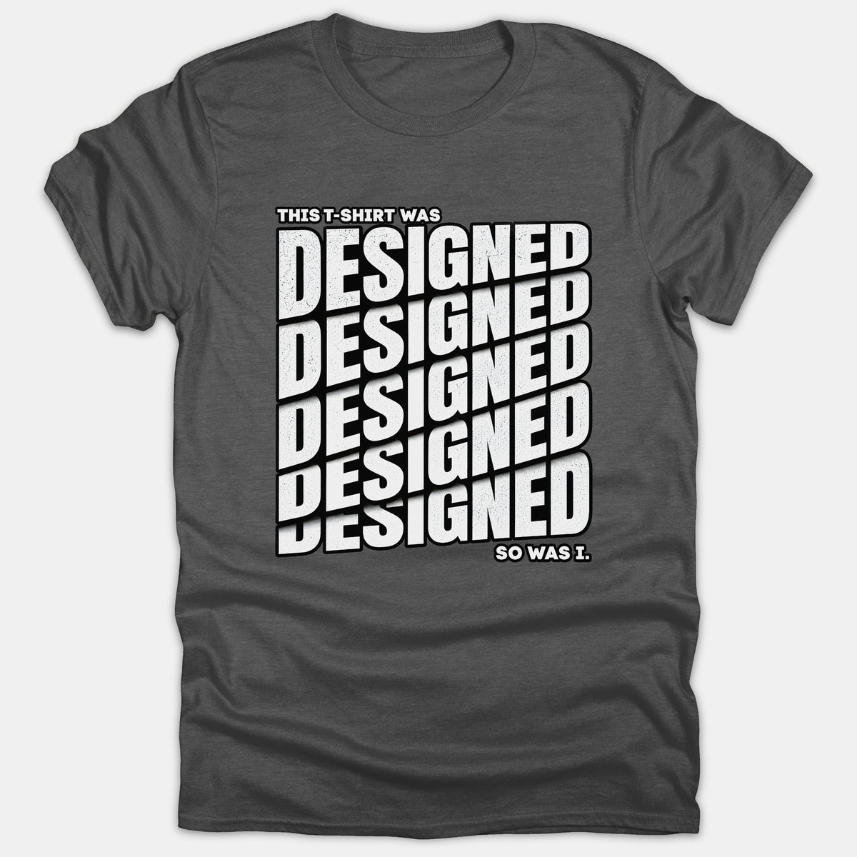 A dark gray Christian t-shirt featuring bold white text reading THIS T-SHIRT WAS DESIGNED SO WAS I with the word DESIGNED stacked repeatedly in a stylized graphic pattern.