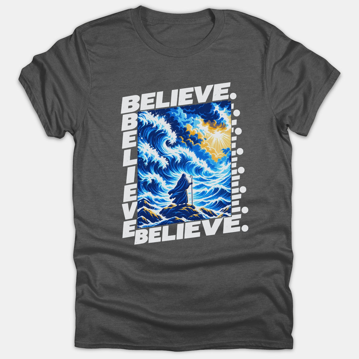 A dark gray t-shirt featuring a framed graphic of a robed figure standing before parting blue ocean waves beneath a bright yellow sky, framed by the word BELIEVE.
