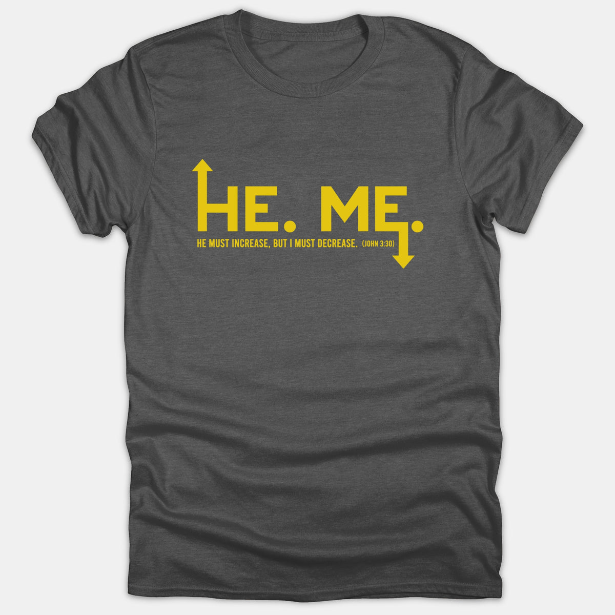 A dark gray Christian t-shirt featuring yellow graphic text reading 'HE' with an up arrow and 'ME' with a down arrow alongside John 3:30.