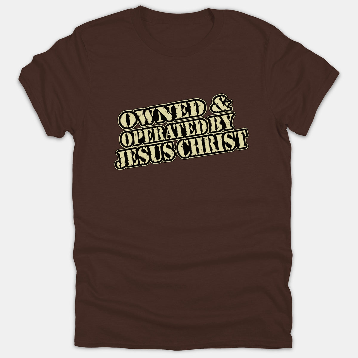 A brown t-shirt featuring a distressed vintage-style typography graphic that reads OWNED & OPERATED BY JESUS CHRIST across the chest.