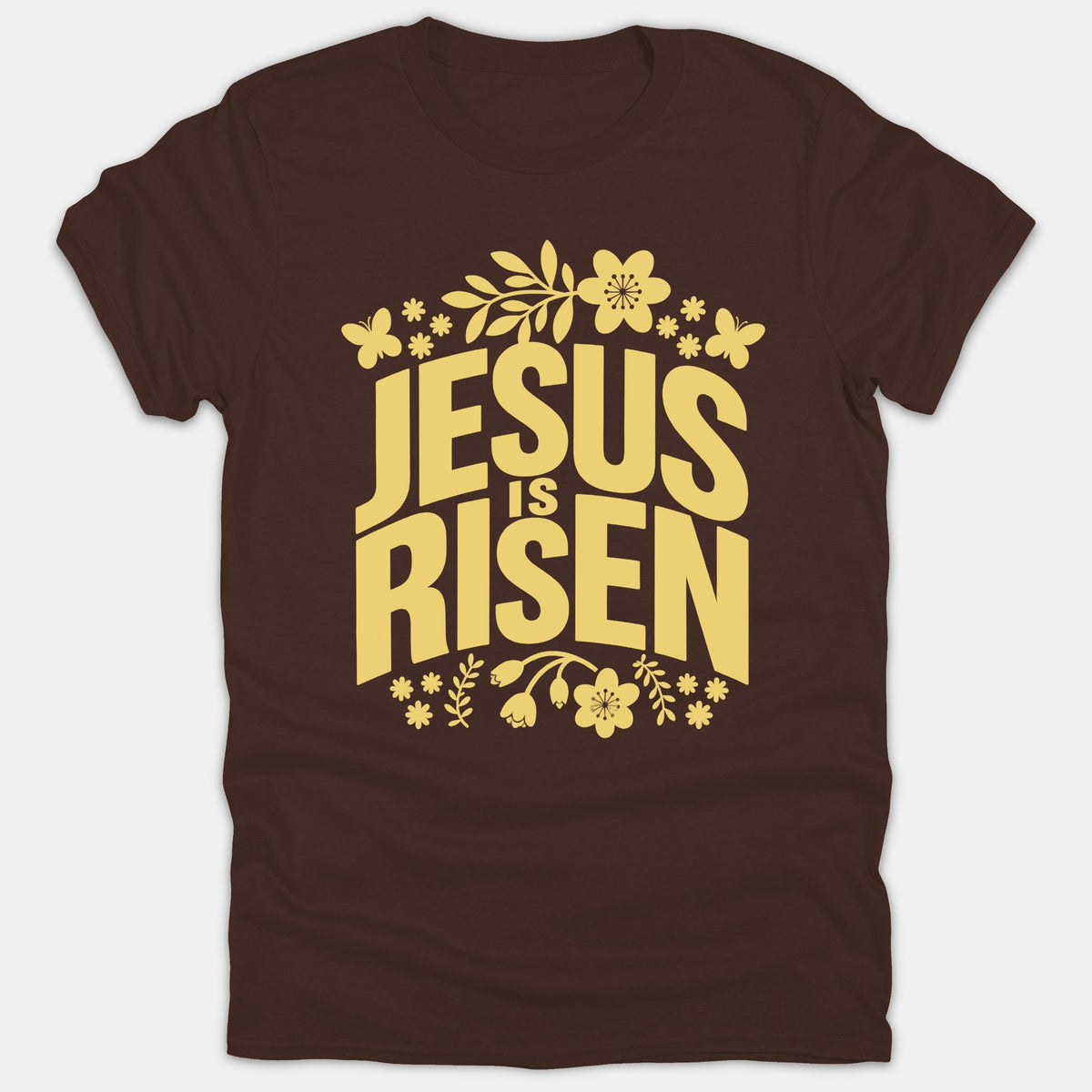 A brown t-shirt featuring the text 'JESUS IS RISEN' in bold yellow typography, framed by decorative flowers and butterflies.