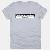 A light gray t-shirt featuring a bold black and white box graphic with text reading 'This T-shirt was designed. So was I.'