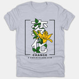 A light gray Christian t-shirt featuring Japanese kanji graphics interwoven with a yellow lily flower, above the word CHANGE and verse reference 2 Corinthians 3:18.