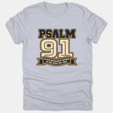A light gray T-shirt featuring a athletic varsity style graphic with Psalm 91 and a banner reading He is my refuge and my fortress; my God, in him I will trust.
