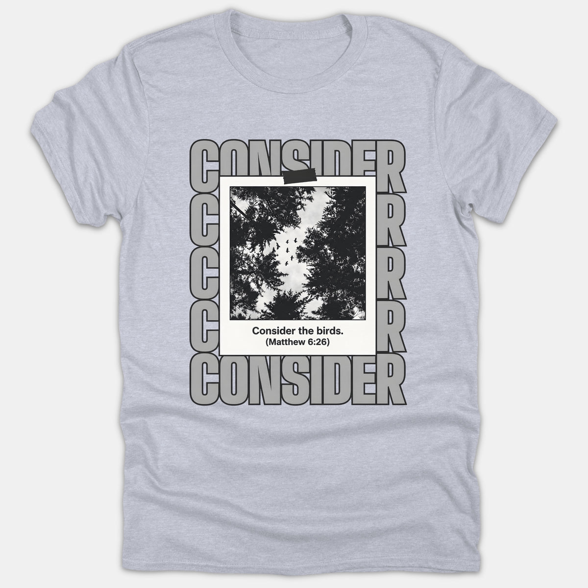 A light gray Christian t-shirt featuring a polaroid photo of birds flying above trees with the Bible verse caption Consider the birds (Matthew 6:26).