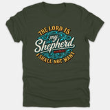 A dark green t-shirt featuring a circular graphic with the Bible verse Psalm 23:1 reading 'The Lord Is My Shepherd I Shall Not Want' styled with decorative blue swirls.